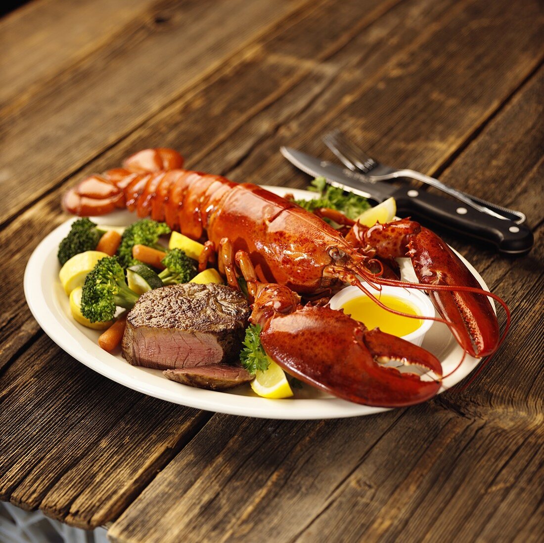 Lobster and beef fillet with vegetables on platter