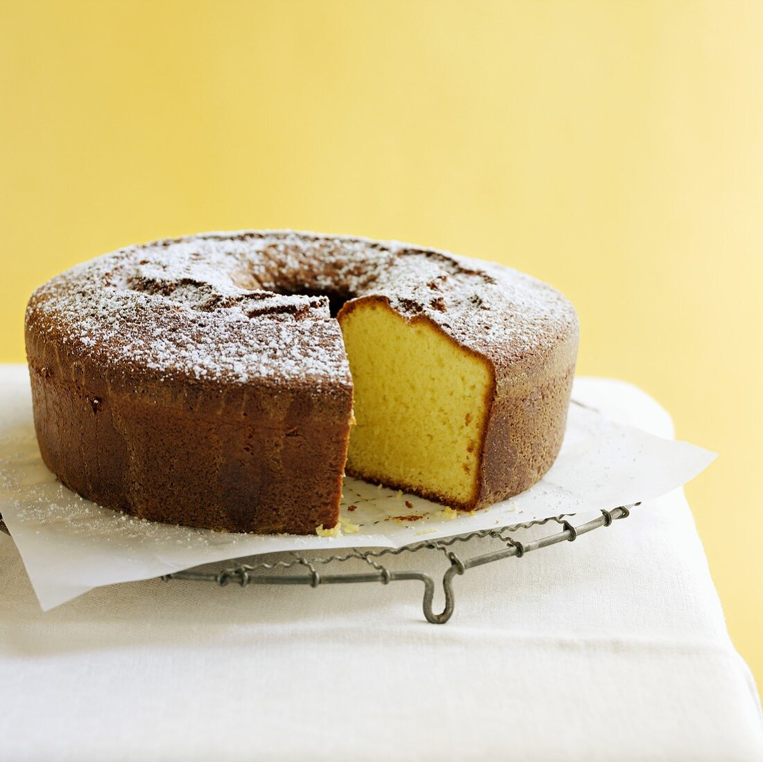 Ring cake with icing sugar on cake rack