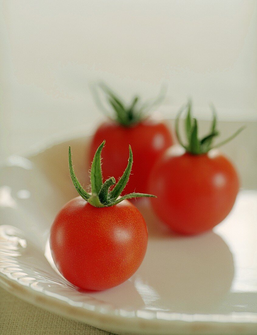 Three cherry tomatoes on white plate