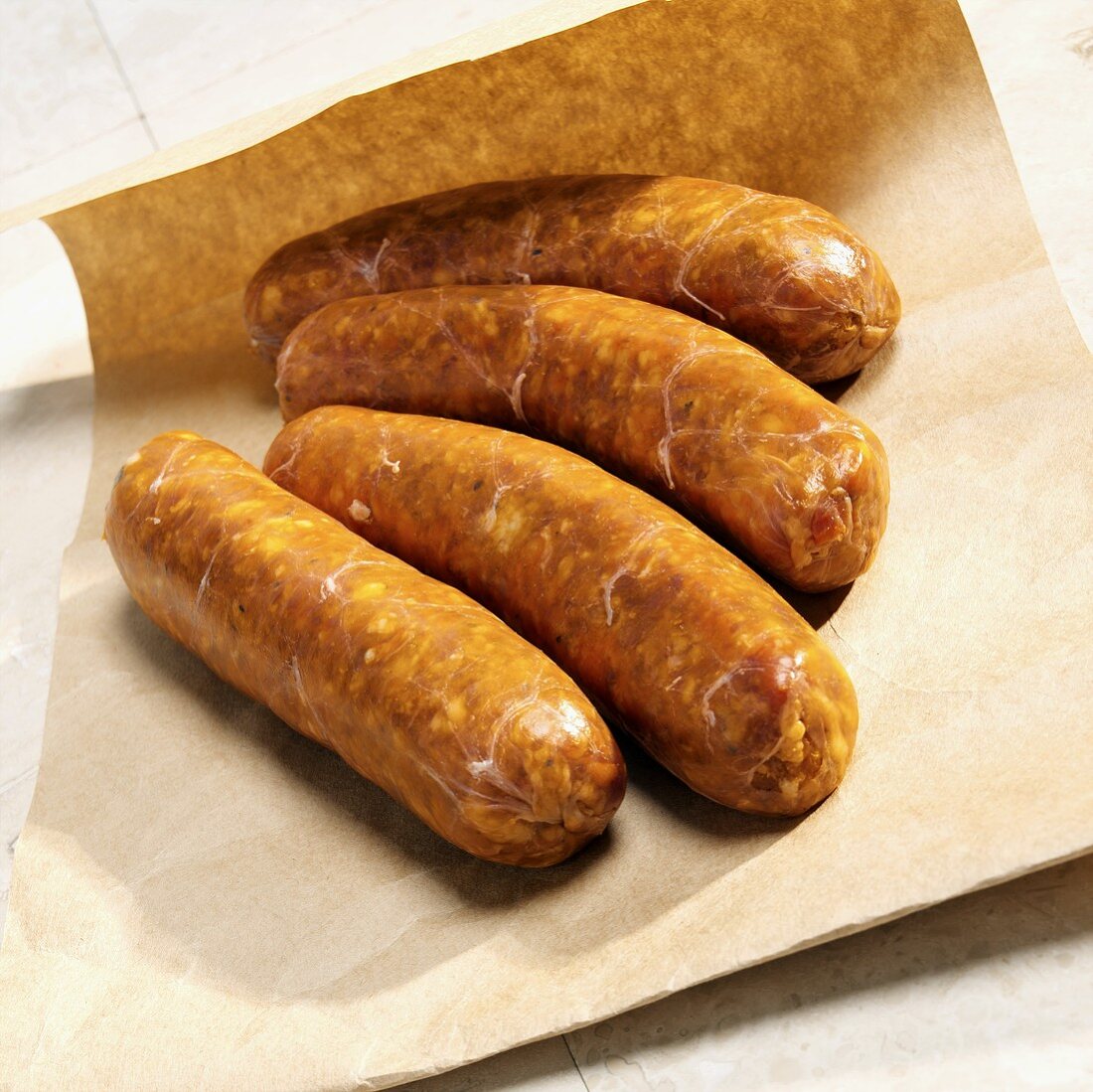 Four Italian sausages on brown paper