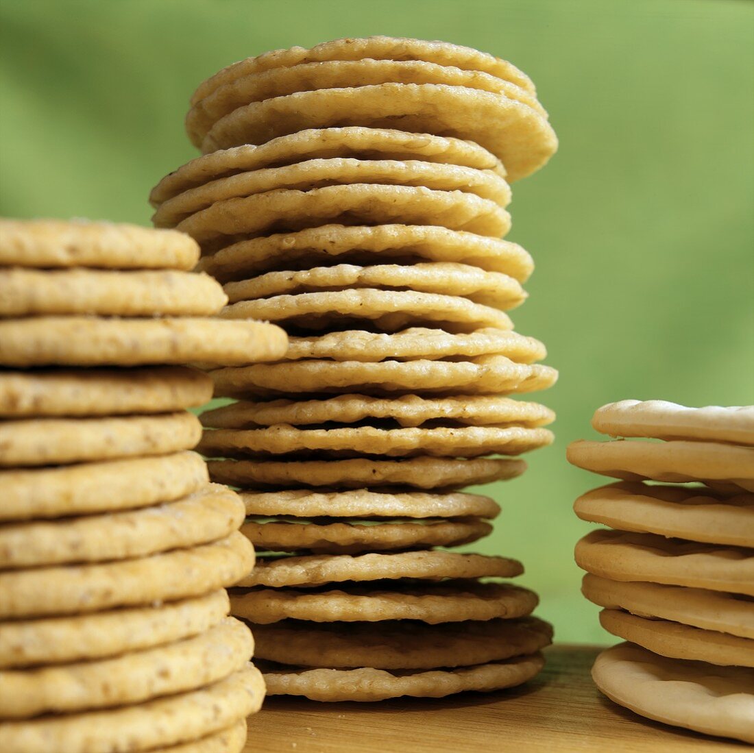 Three piles of crackers against green background