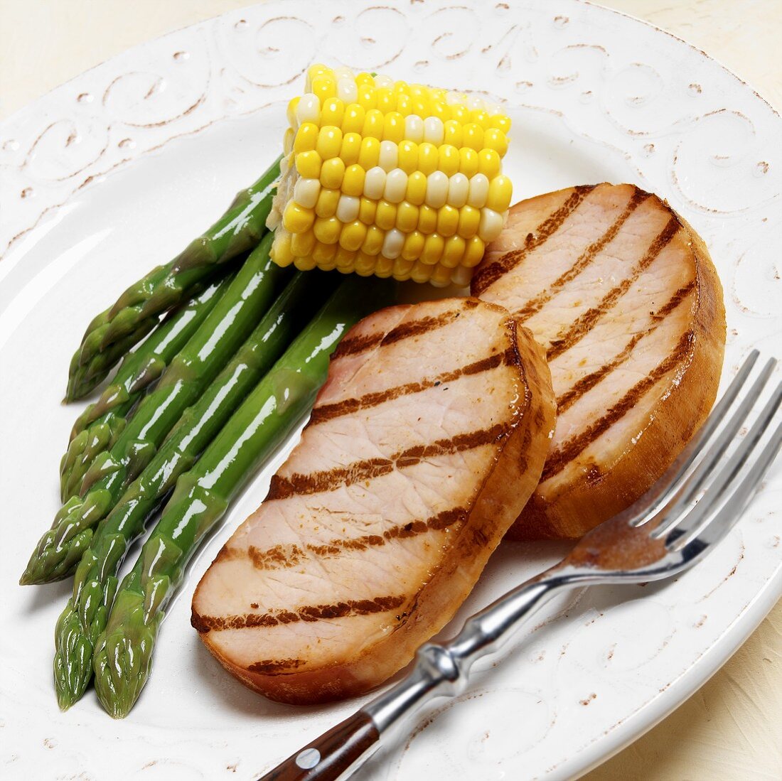 Two grilled smoked pork chops with green asparagus & sweetcorn