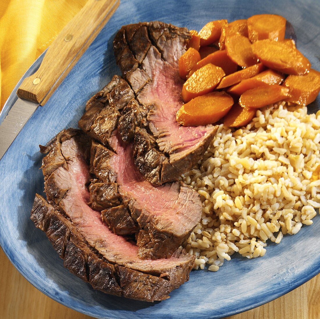 Slices of beef steak with carrots and rice