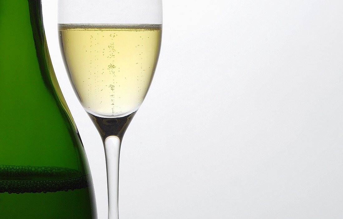 Glass of champagne beside bottle