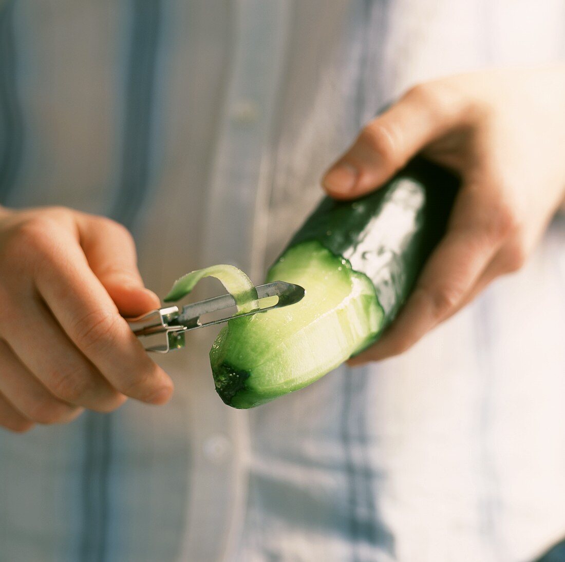 A Person Peeling a Cucumber