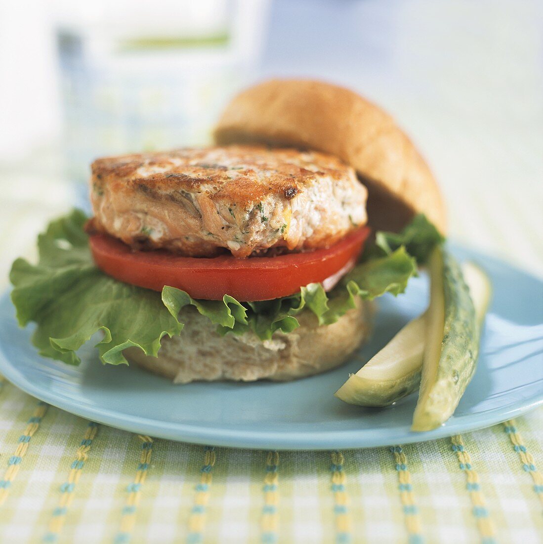 A Fried Salmon Cake on a Roll with Tomato and Lettuce