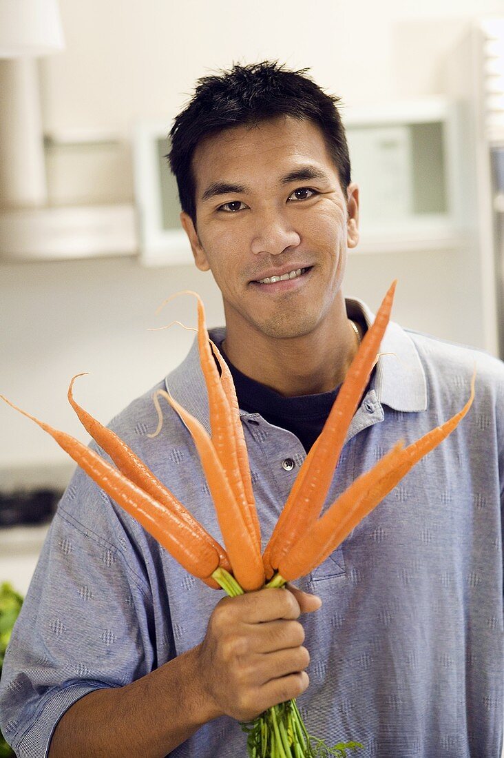 A Man Holding a Bunch of Fresh Carrots