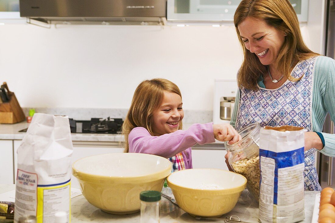 A Woman and a Little Girl Making Oatmeal Cookies in the Kitchen