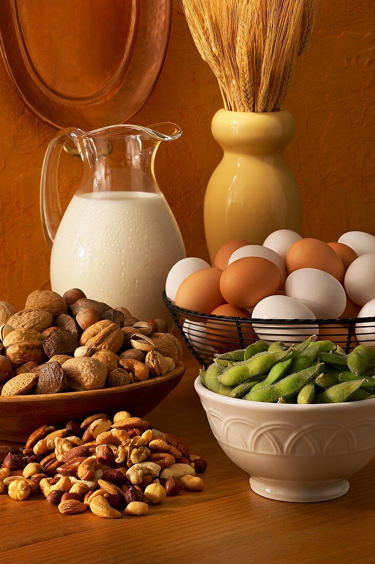 Stillleben mit Nüssen, Eiern, Milch, Ähren und Bohnen