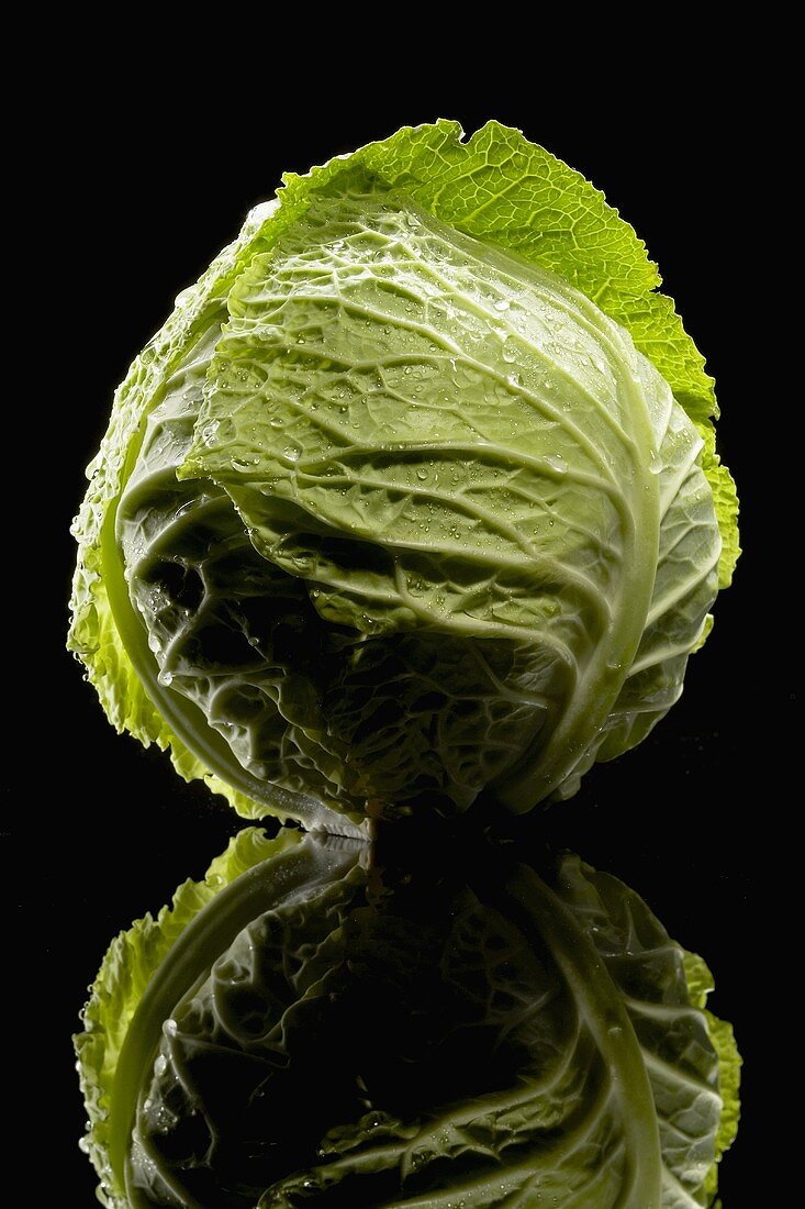 A Head of Cabbage on Black Background with Reflexion