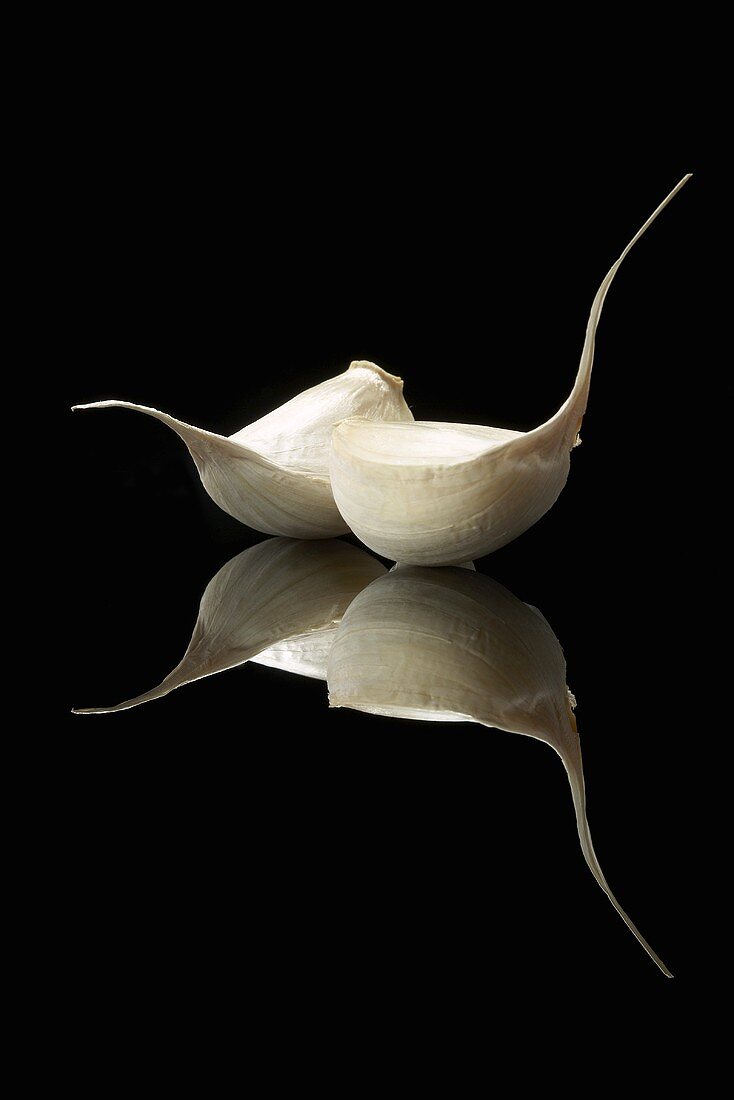 Two Cloves of Garlic on Black with Reflection