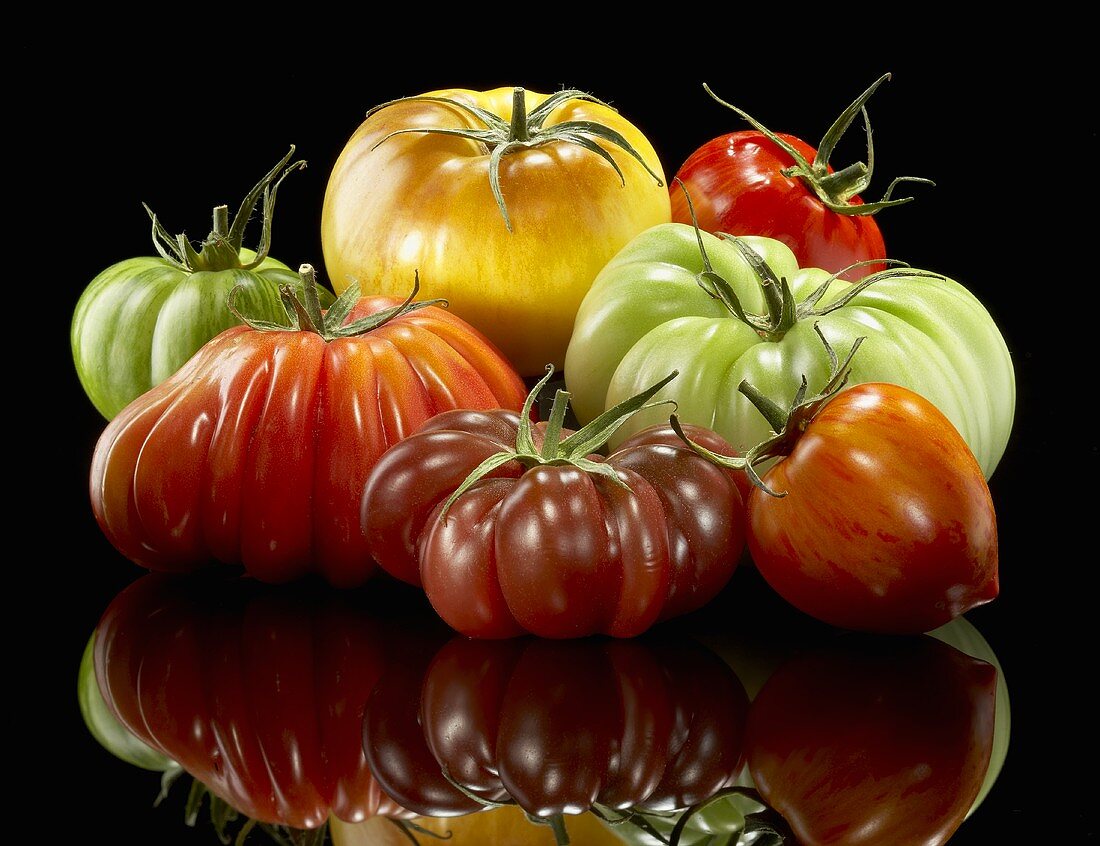 Colorful Assorted Heirloom Tomatoes on Black with Reflection
