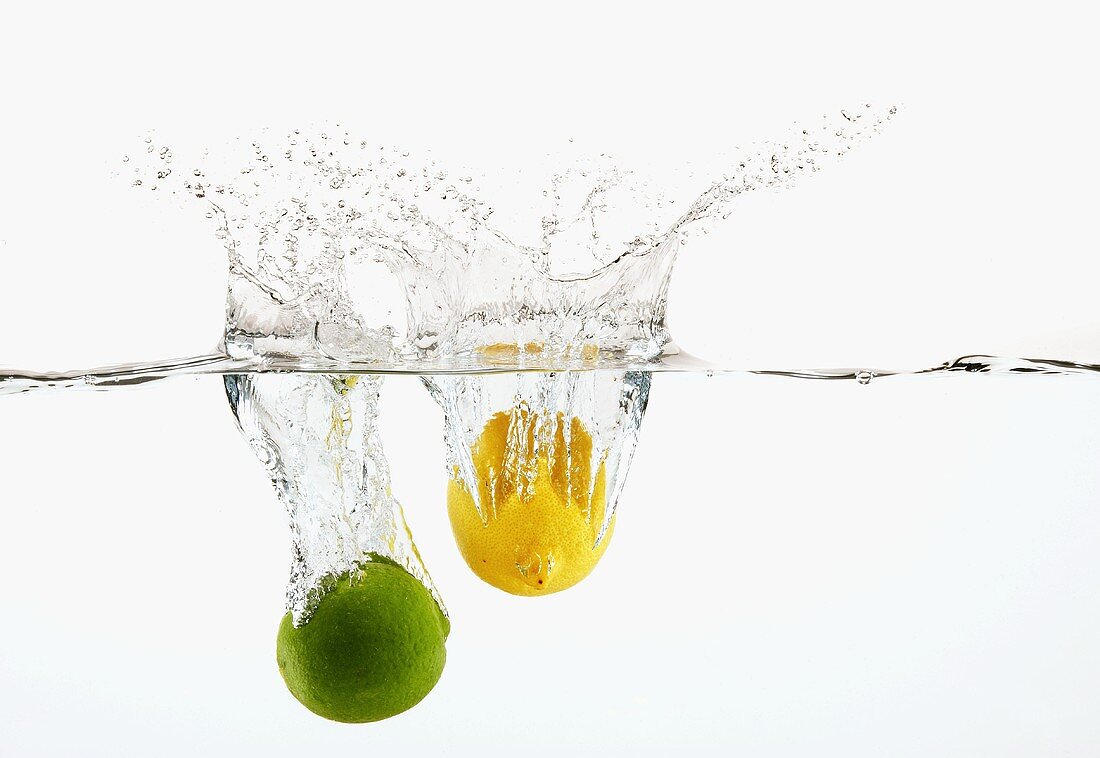 Limette und Zitrone fallen ins Wasser
