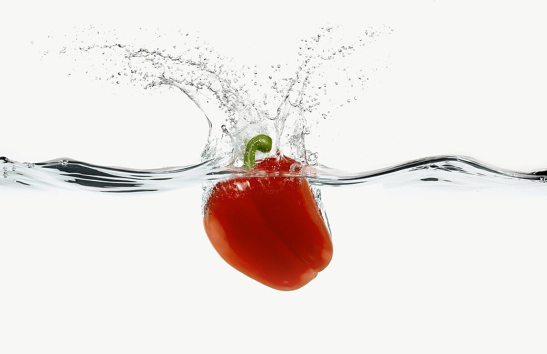 A Red Bell Pepper Splashing into Water