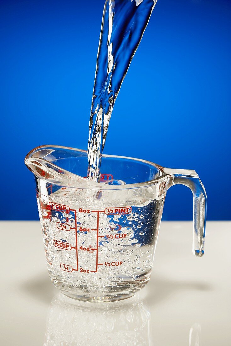 Pouring Water into a Glass Measuring Pitcher