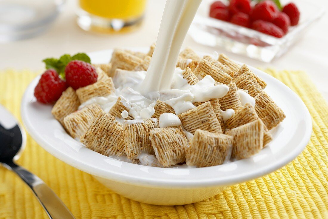 Milk Pouring Over Shredded Wheat Cereal