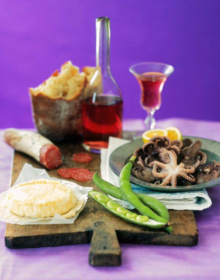 Italian Still Life with Fresh Calamari, Bread, Cheese, Salami, Green Beans and Red Wine on a Wooden Board