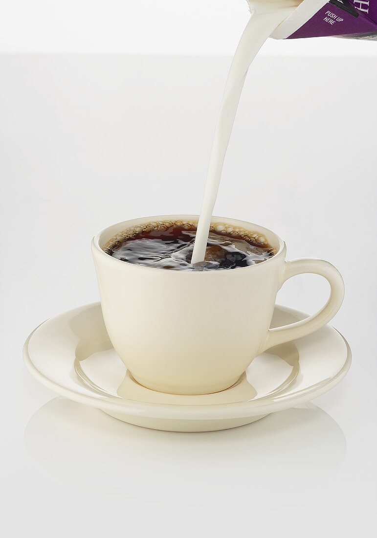 Pouring Milk Into A Cup Of Coffee License Images Stockfood