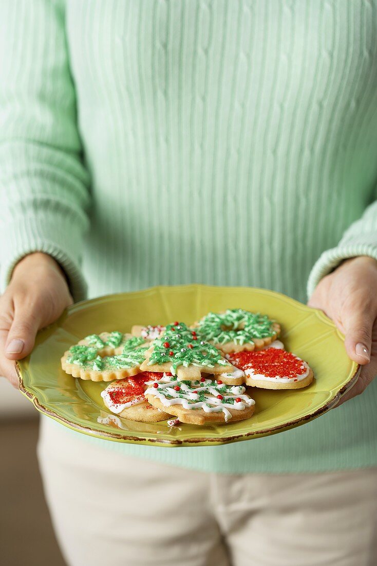 A Woman Holding a Plate of Christmas Cookies