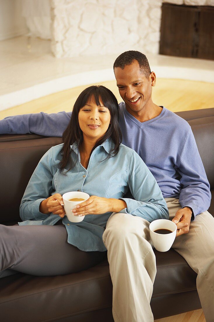Couple having coffee break on sofa