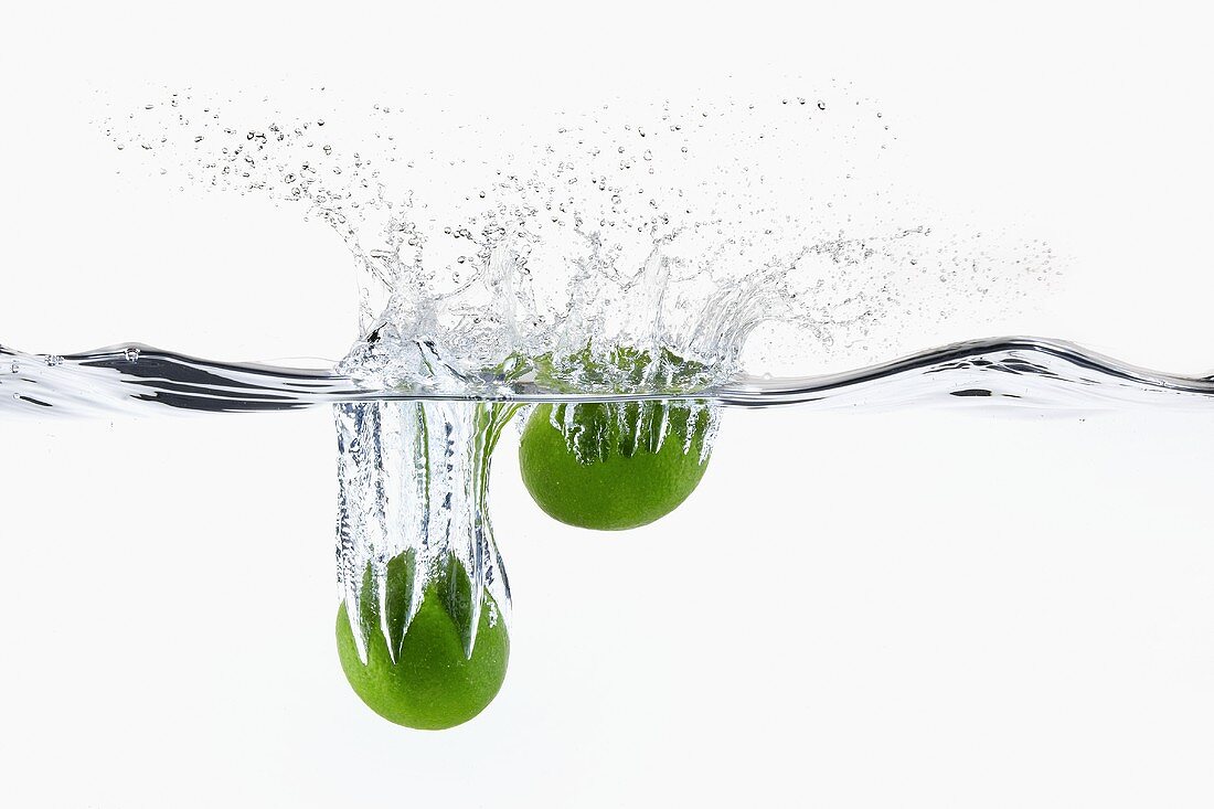Two Limes Splashing into Water