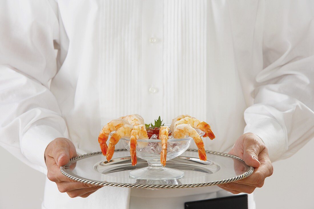A Waiter Holding a Tray with Shrimp Cocktail