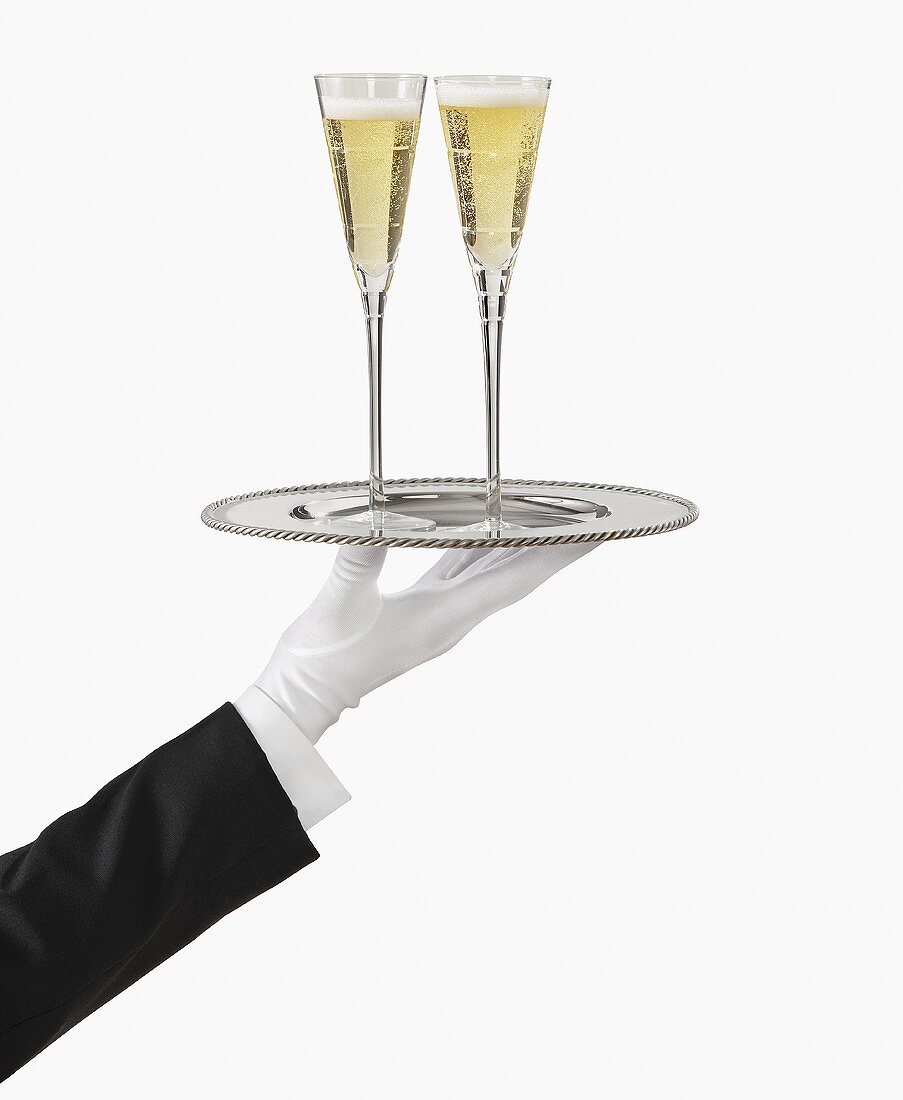 A Gloved Hand Holding a Silver Tray with Two Glasses of Champagne