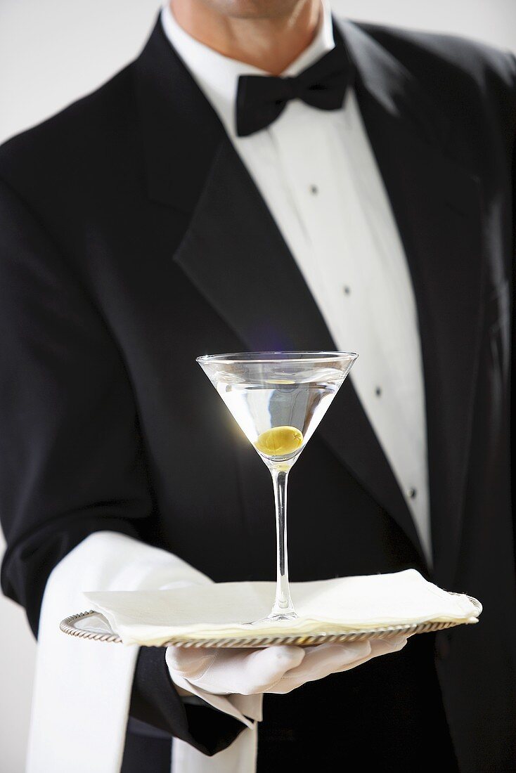 Butler holding glass of Martini on silver tray
