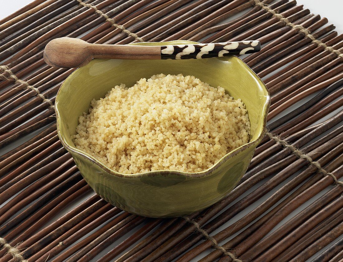 Couscous in grüner Schale mit Holzlöffel