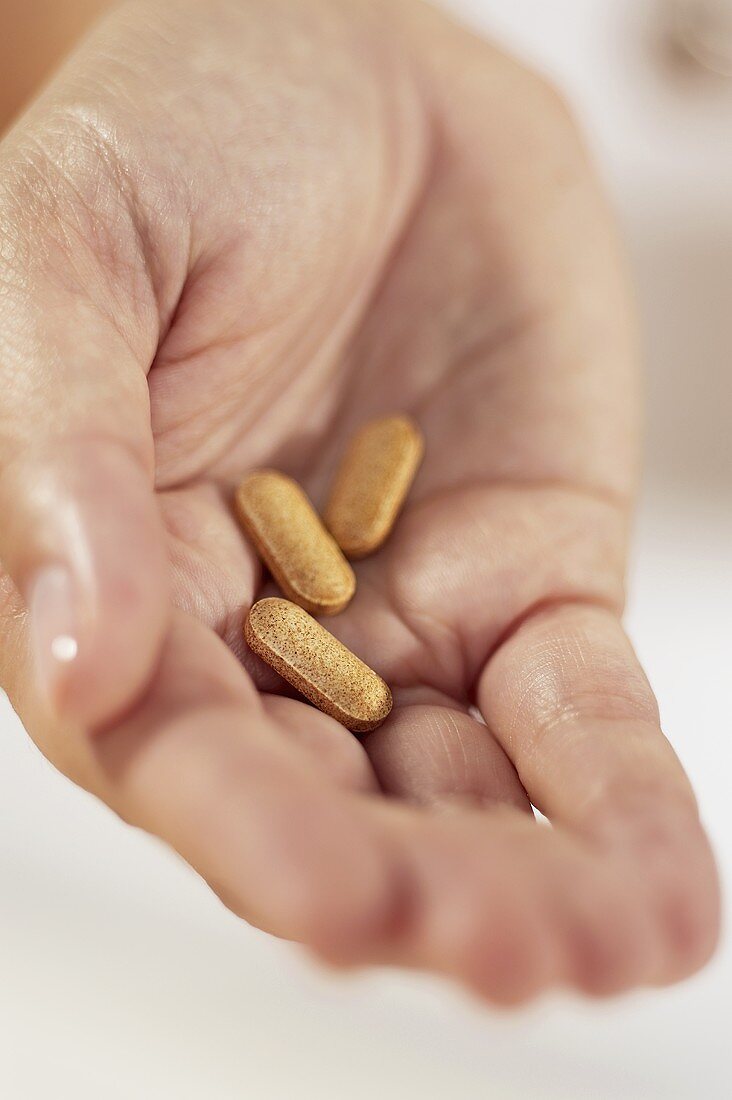 Hand hält Tabletten