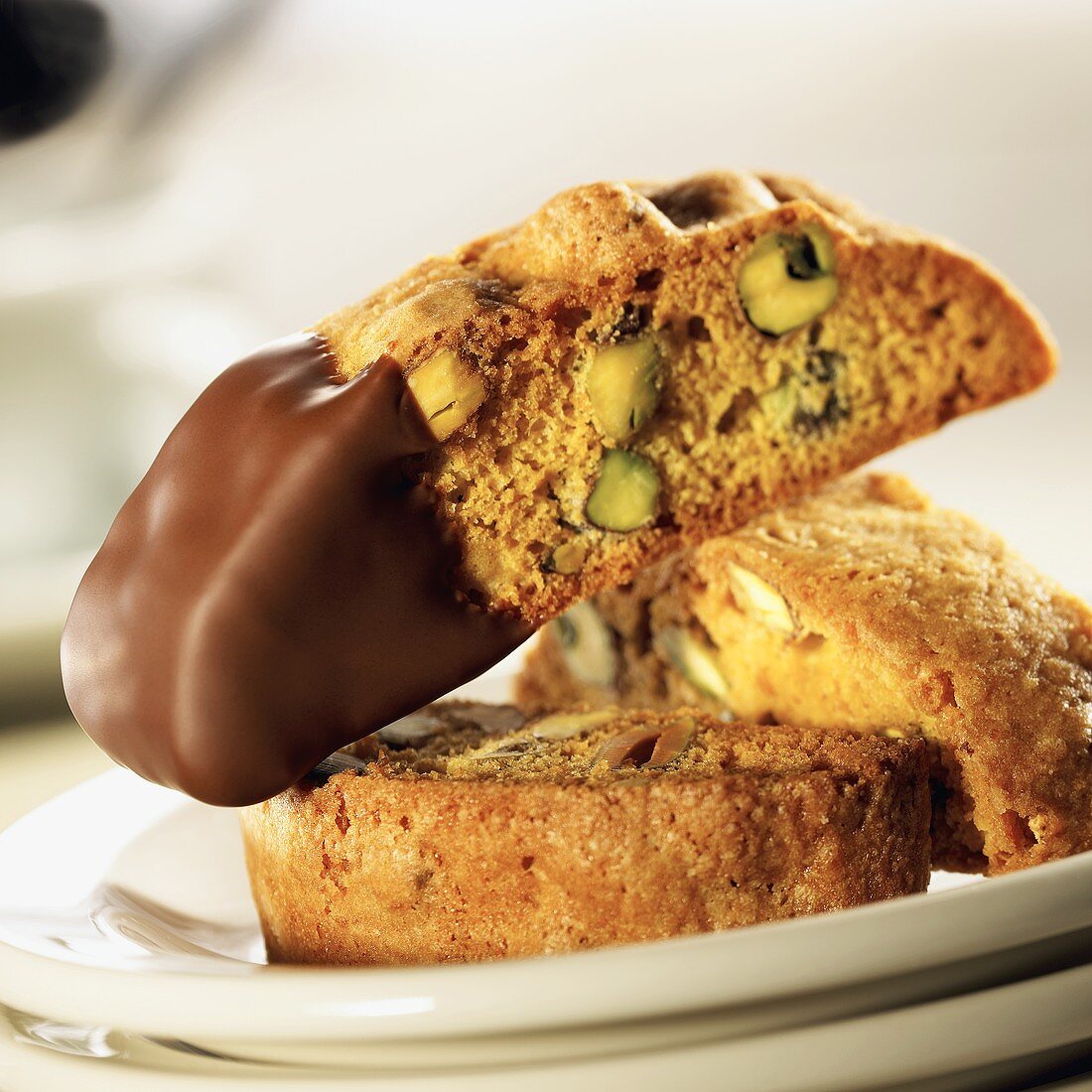 Three Pistachio-Orange Biscotti, One Dipped in Chocolate