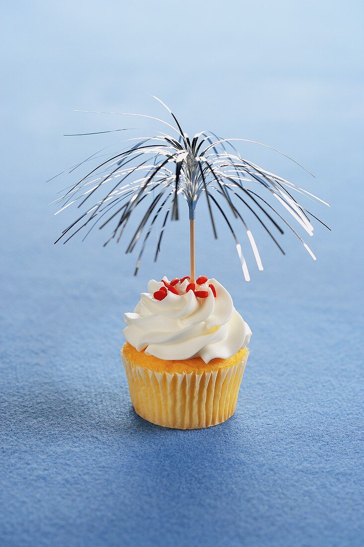 A Yellow Cupcake with Festive Tinsel Toothpick Decoration