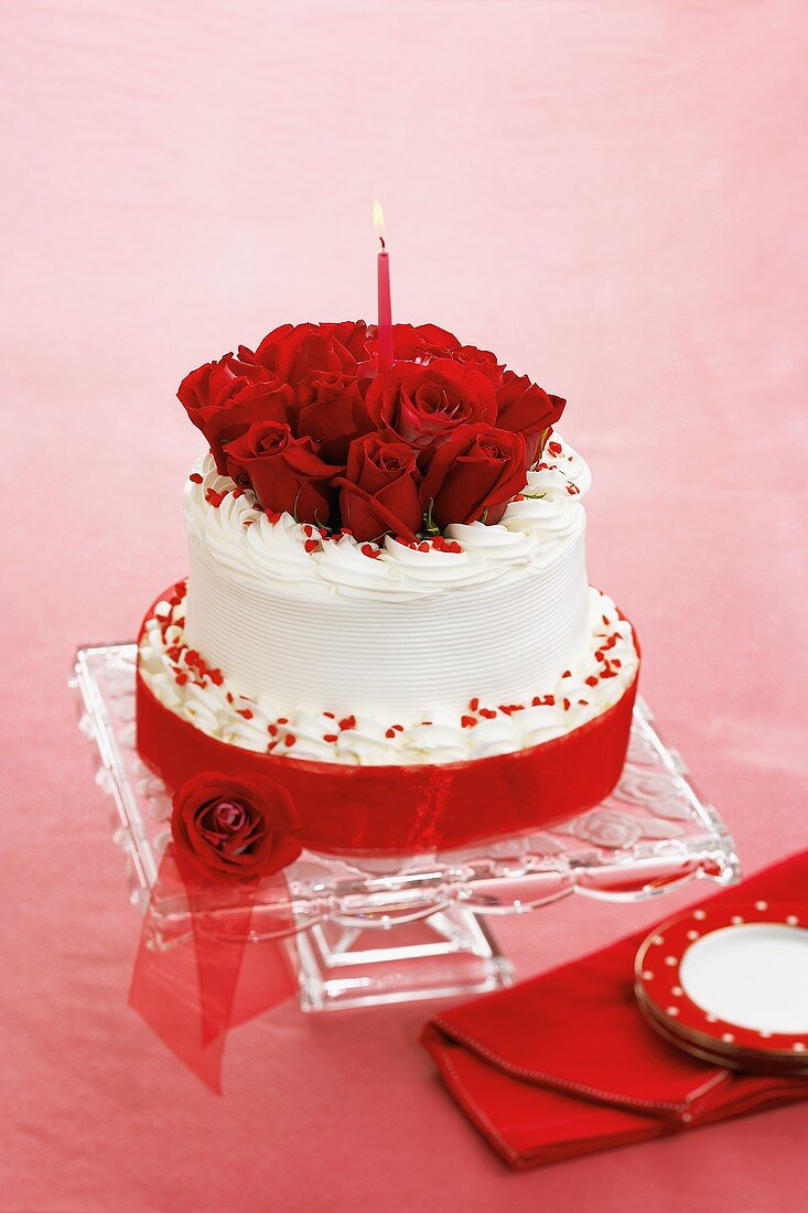 Torte zum Valentinstag mit roten Rosen und Kerze