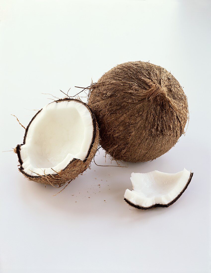 A Whole and an Opened Coconut on White