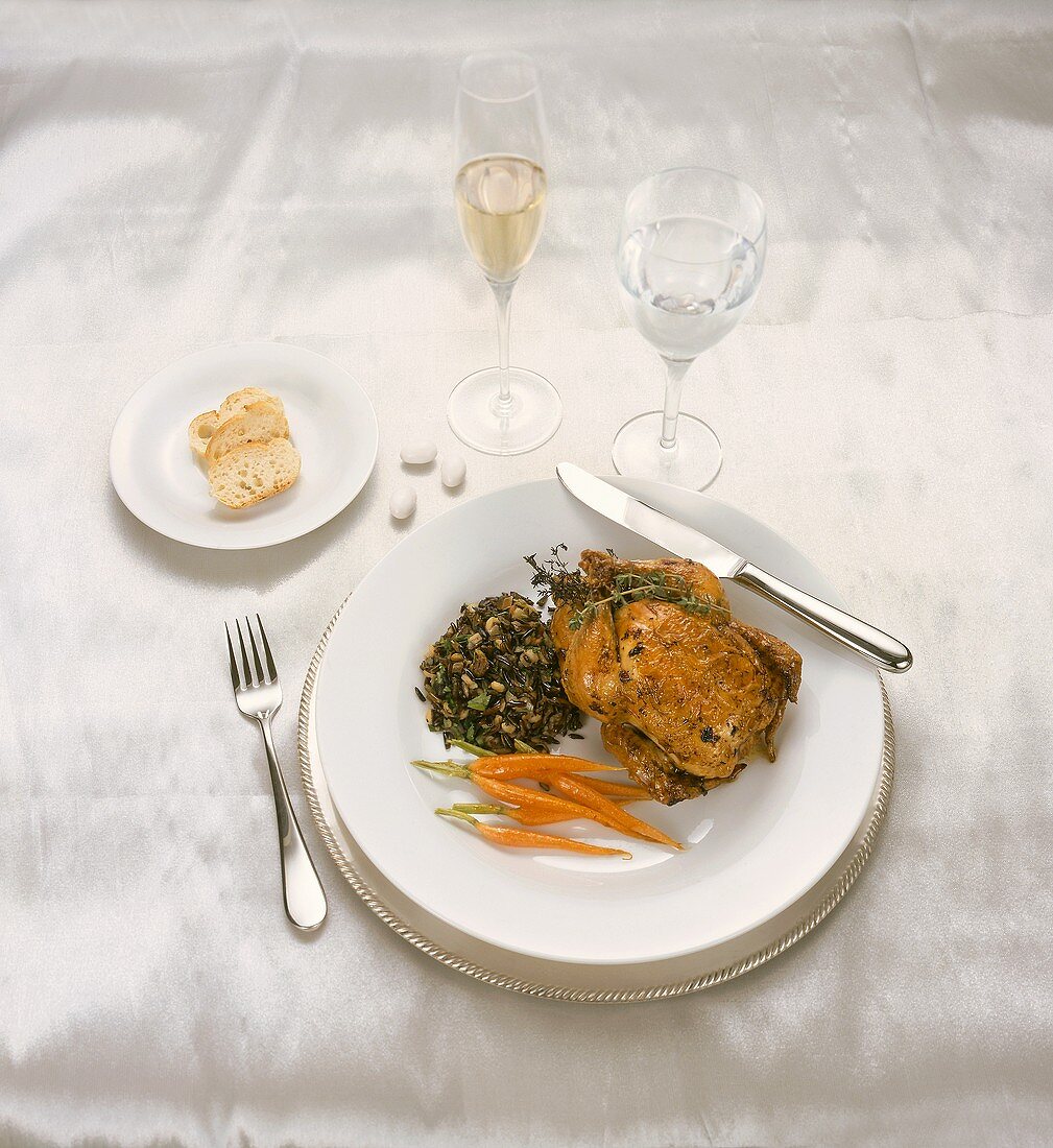 A Place Setting with Cornish Game Hen, Carrots, Wild Rice, Bread, Mints and Wine