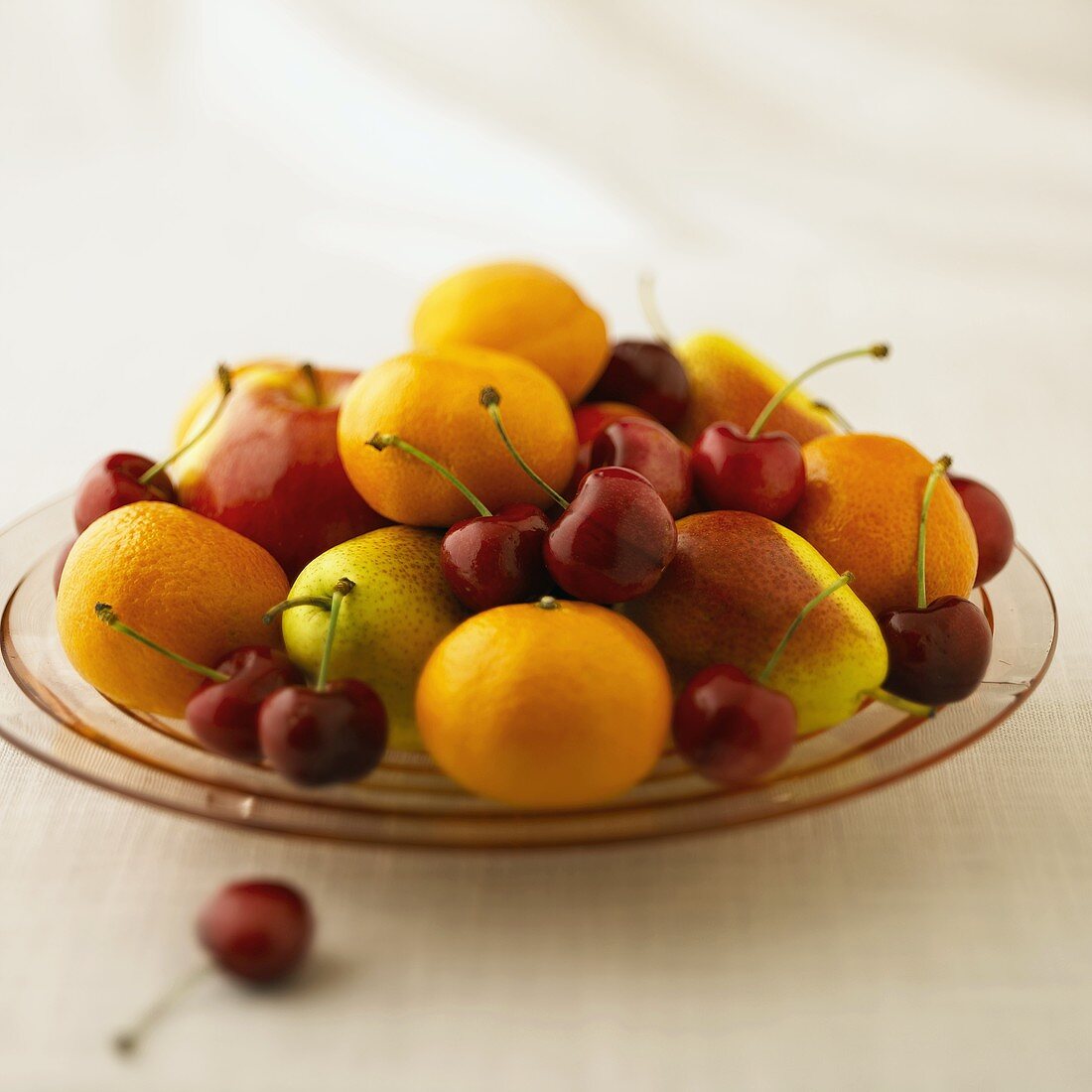 Obstteller mit Clementinen, Forellenbirnen und Kirschen