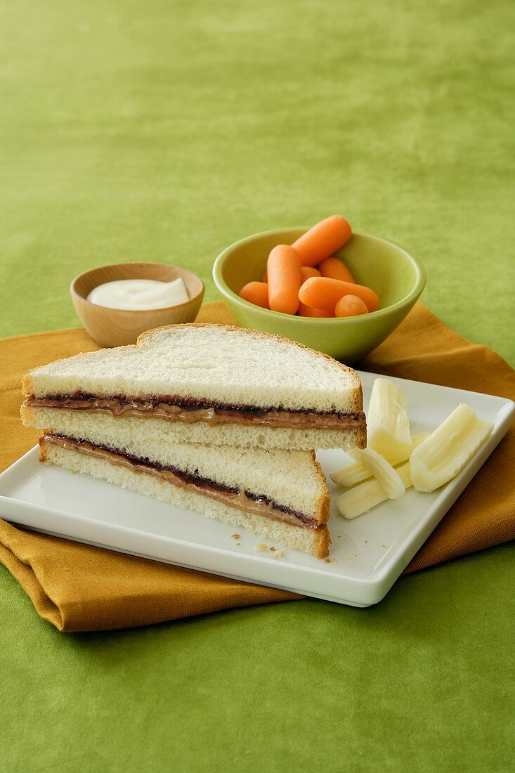 A Peanut Butter and Jelly Sandwich (PB&J) with String Cheese, Baby Carrots and Dip (Child's Lunch)