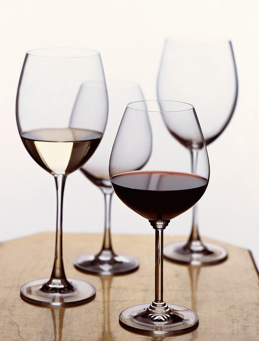 A Glass of Red and a Glass of White Wine with Two Empty Glasses