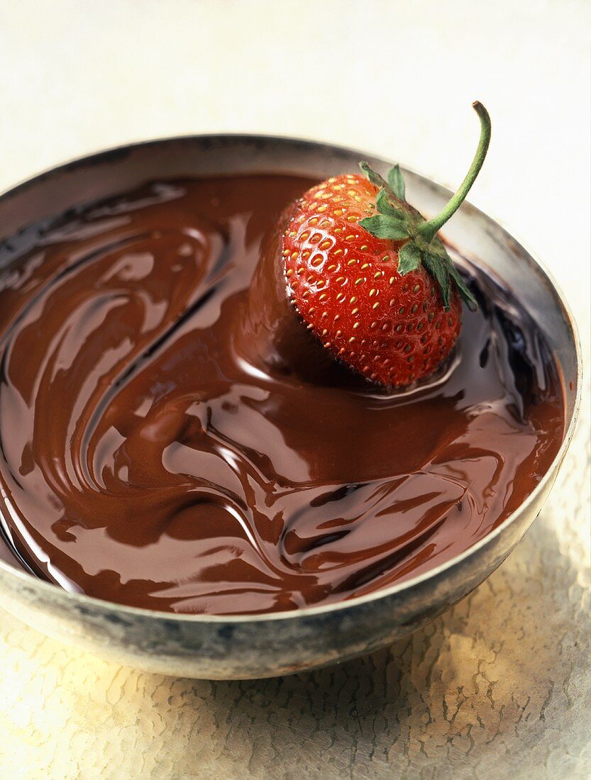 A Strawberry in a Bowl of Melted Chocolate