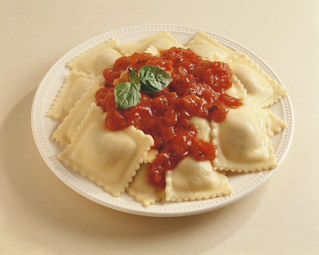 Ravioli on white plate with tomato sauce