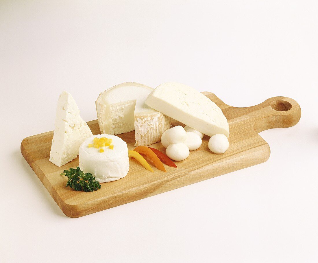 Assorted Soft Cheeses on a Wooden Board