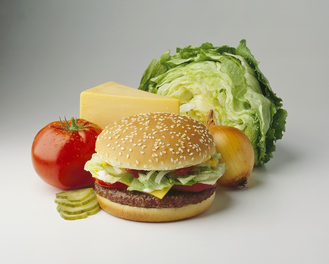 Cheeseburger with topping ingredients behind