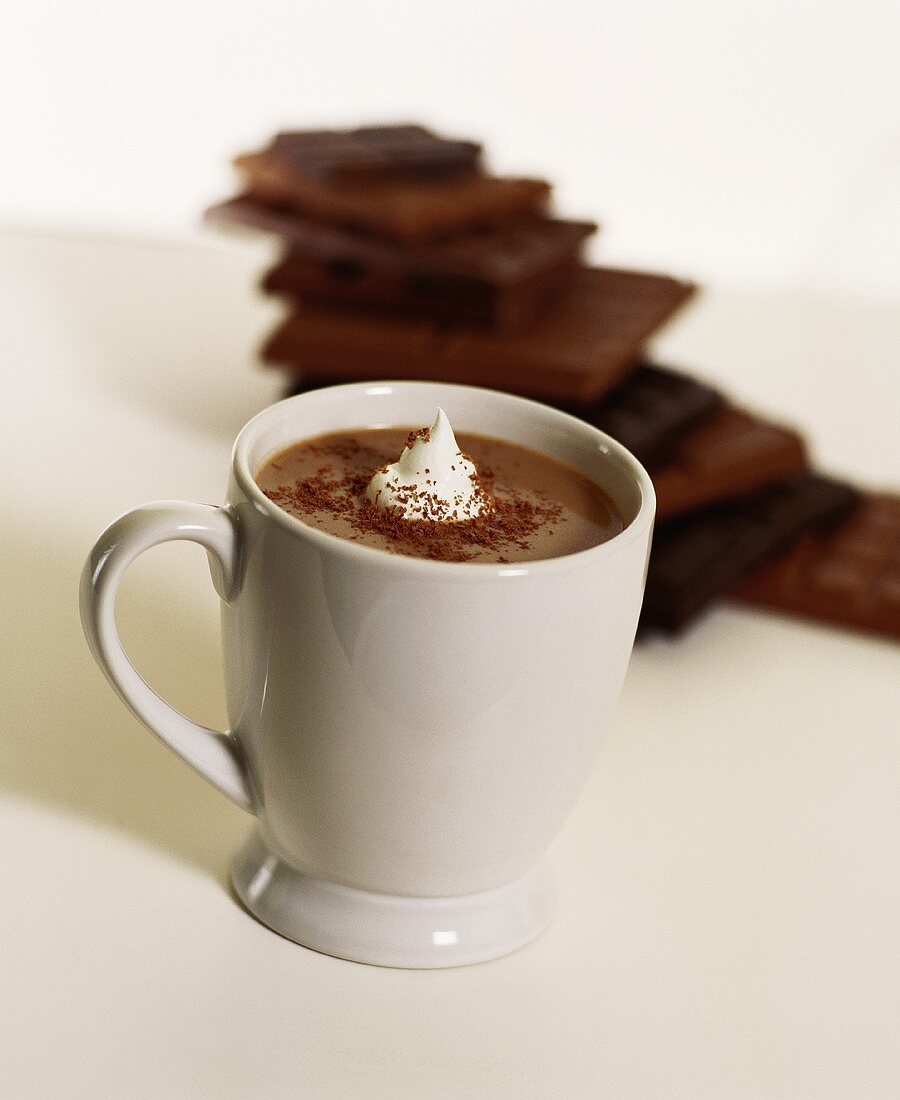 A cup of hot chocolate with whip cream and cocoa
