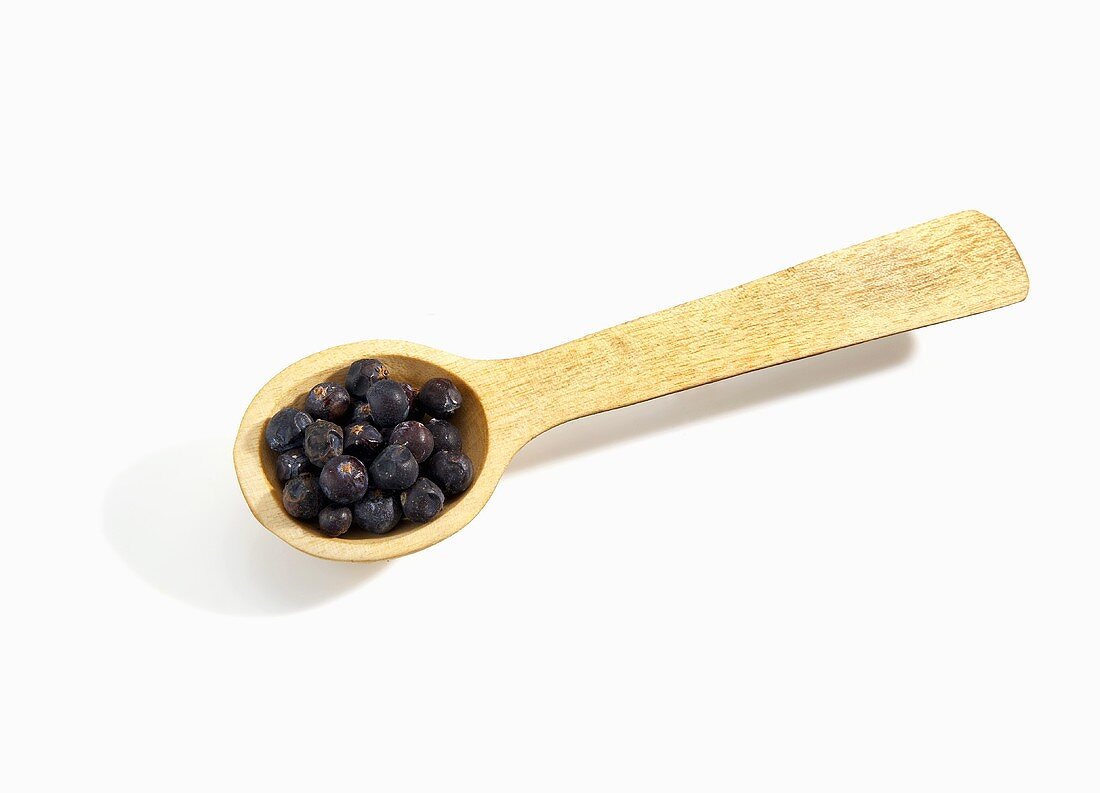 Wooden Spoonful of Juniper Berries on White Background