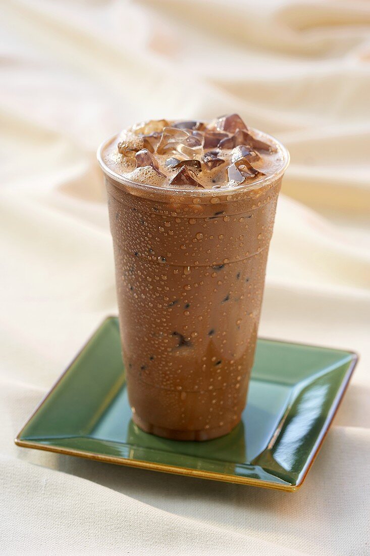 Chocolate Iced Latte Served in a Tall Glass on a Green Square Dish