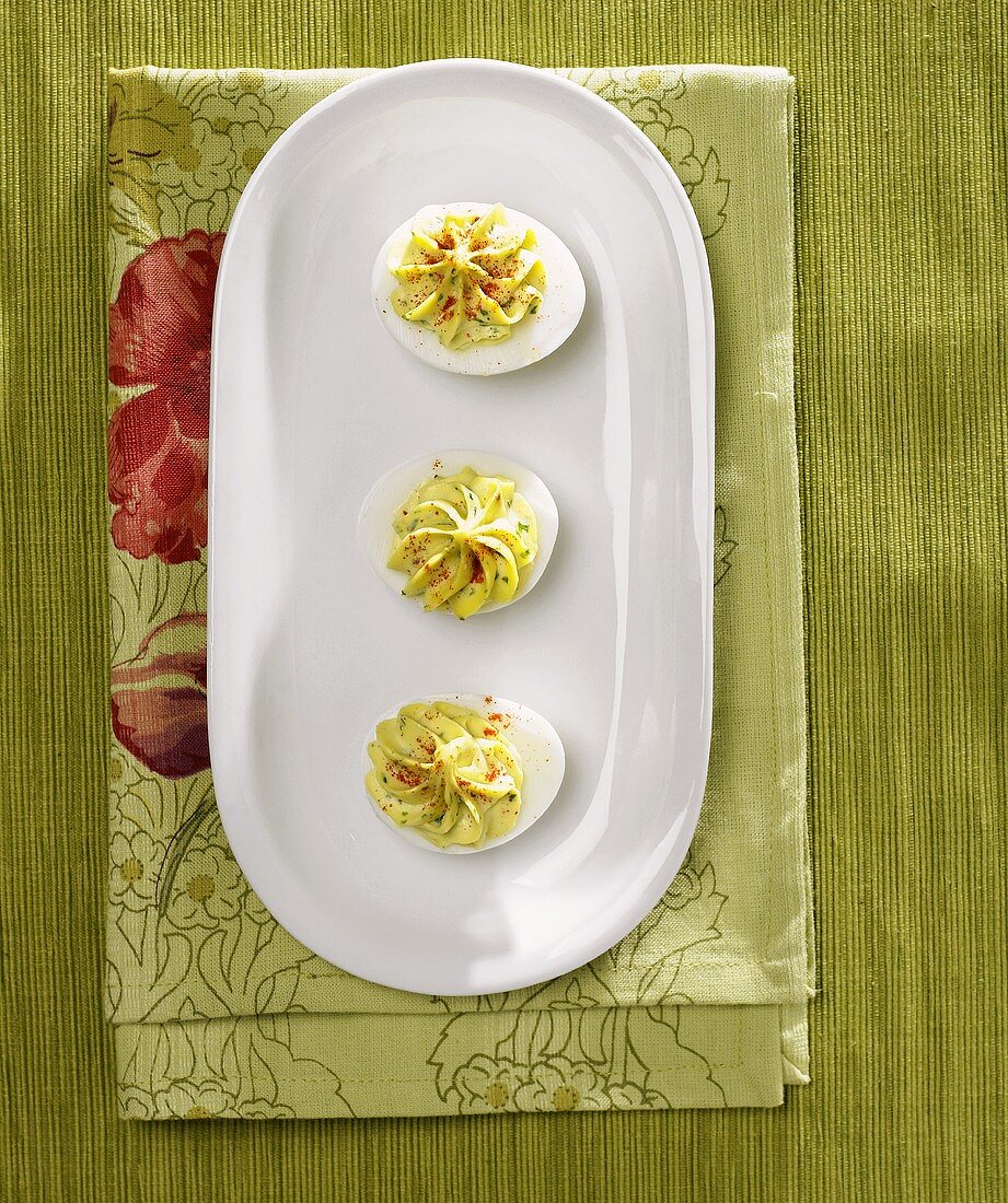 Overhead of Three Deviled Eggs on a White Oval Platter