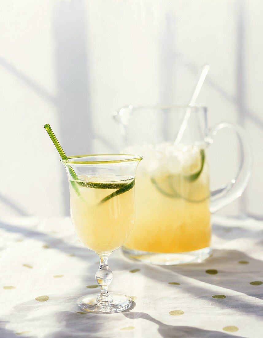 Glass of Limeade with Green Stirrer and Lime Slice; Pitcher of Limeade