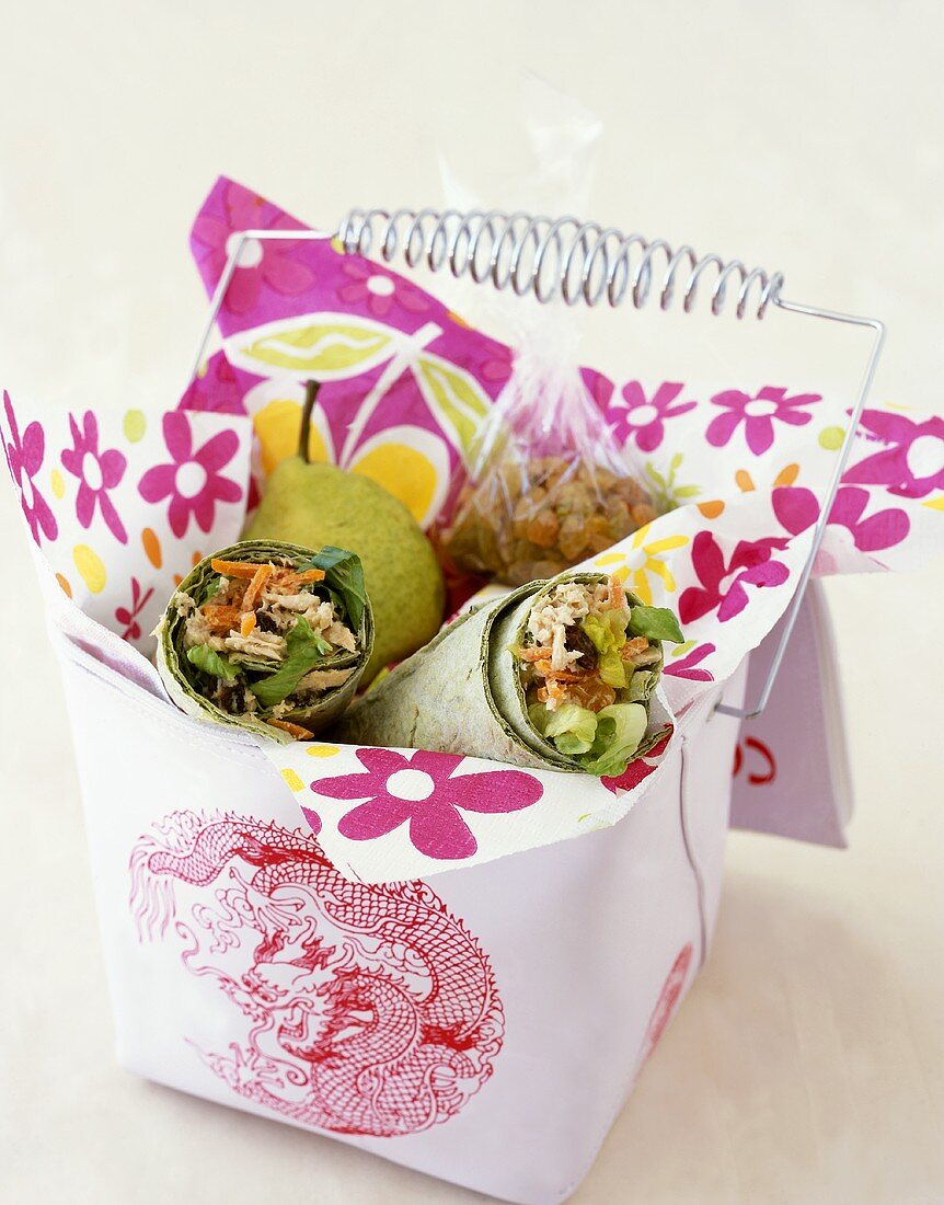 Gesunde Lunchbox mit Hähnchen-Wraps, Birne und Rosinen