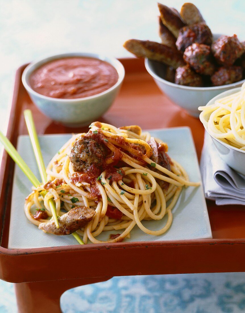 Serving of Spaghetti with Sausage, Meatballs and Marinara Sauce; Bowl of Pasta and Bowls of Toppings