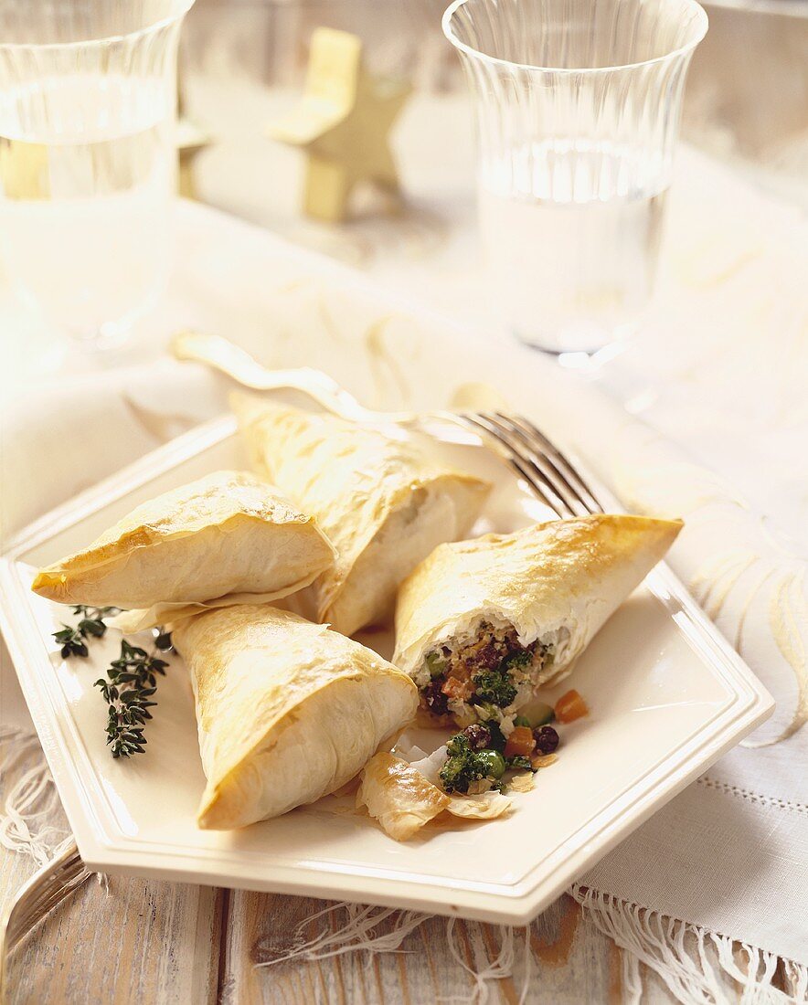 Vegetable Filled Pastry Pockets on a Plate; One Split Open